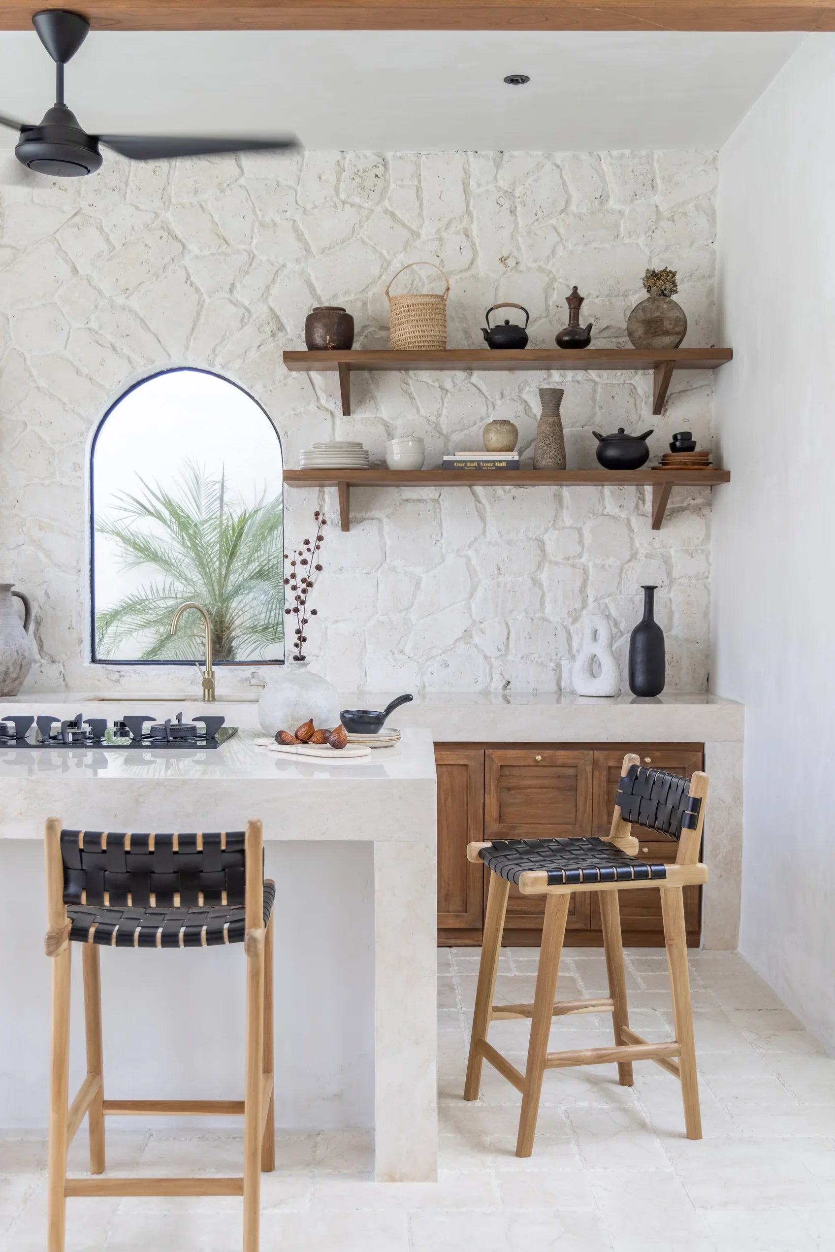 black leather and teak stool in a kitchen with floating wooden shelves