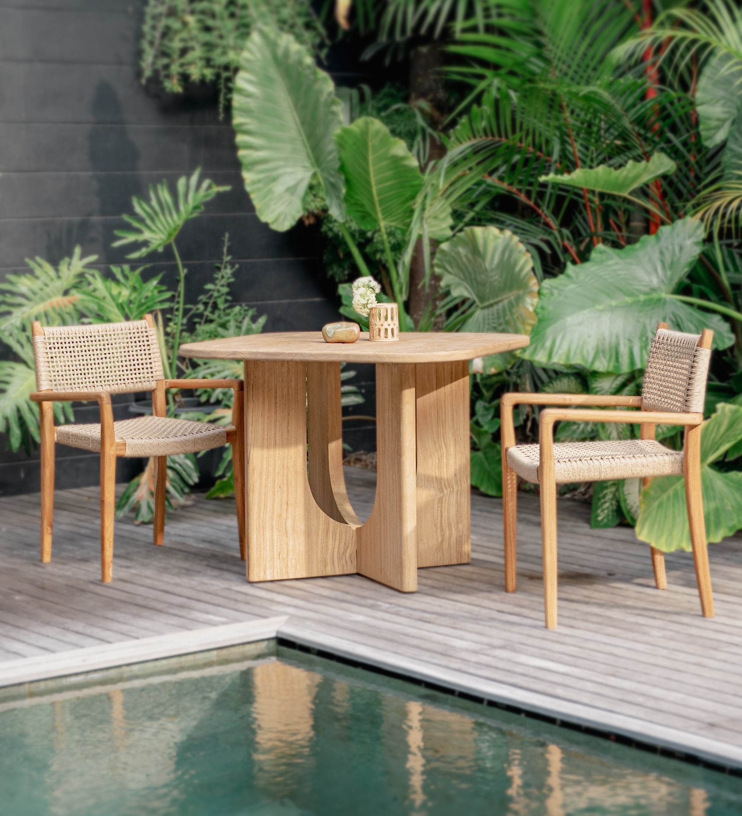 outdoor table and chairs set up by a pool 