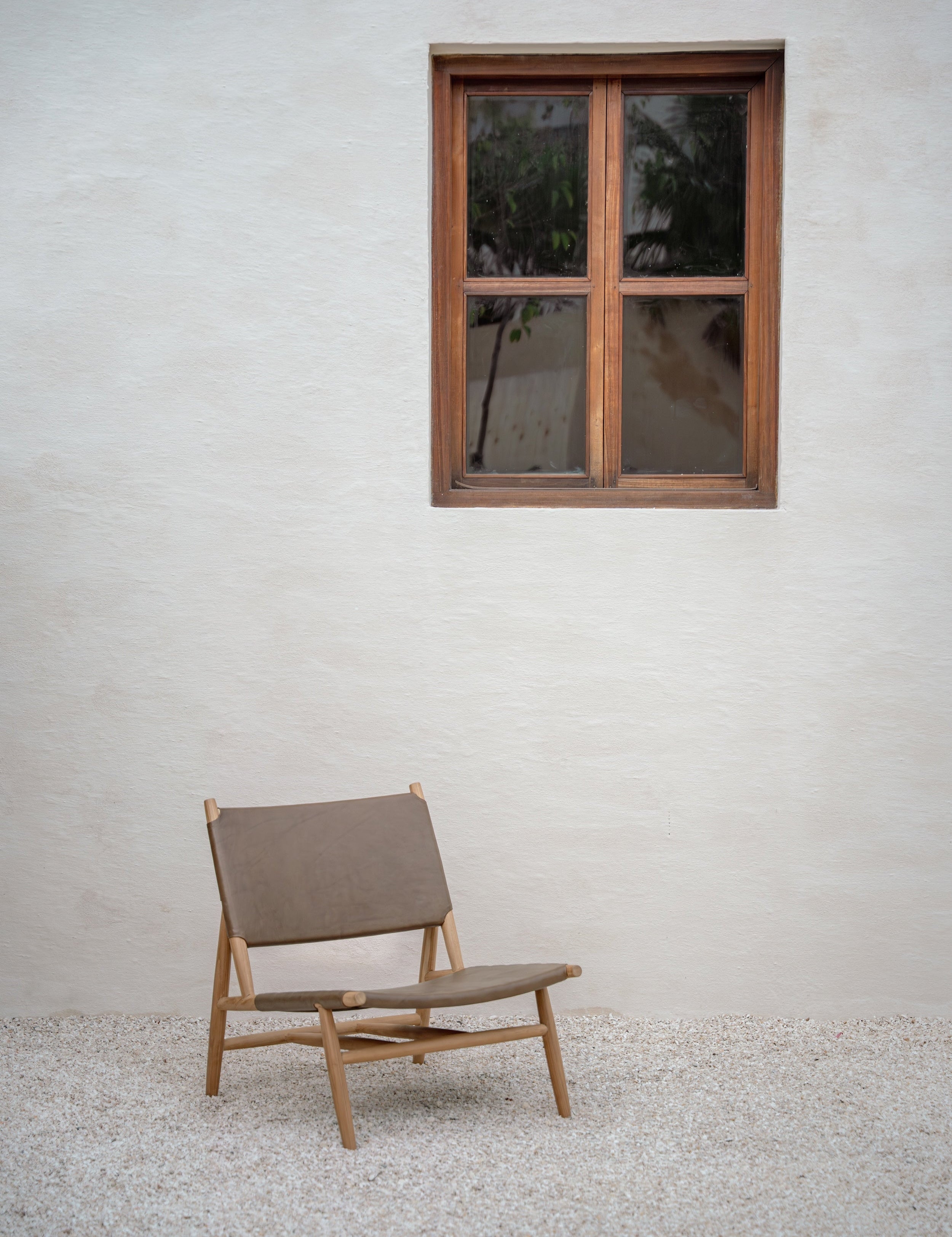 Leather and teak lounge chair in a small courtyard