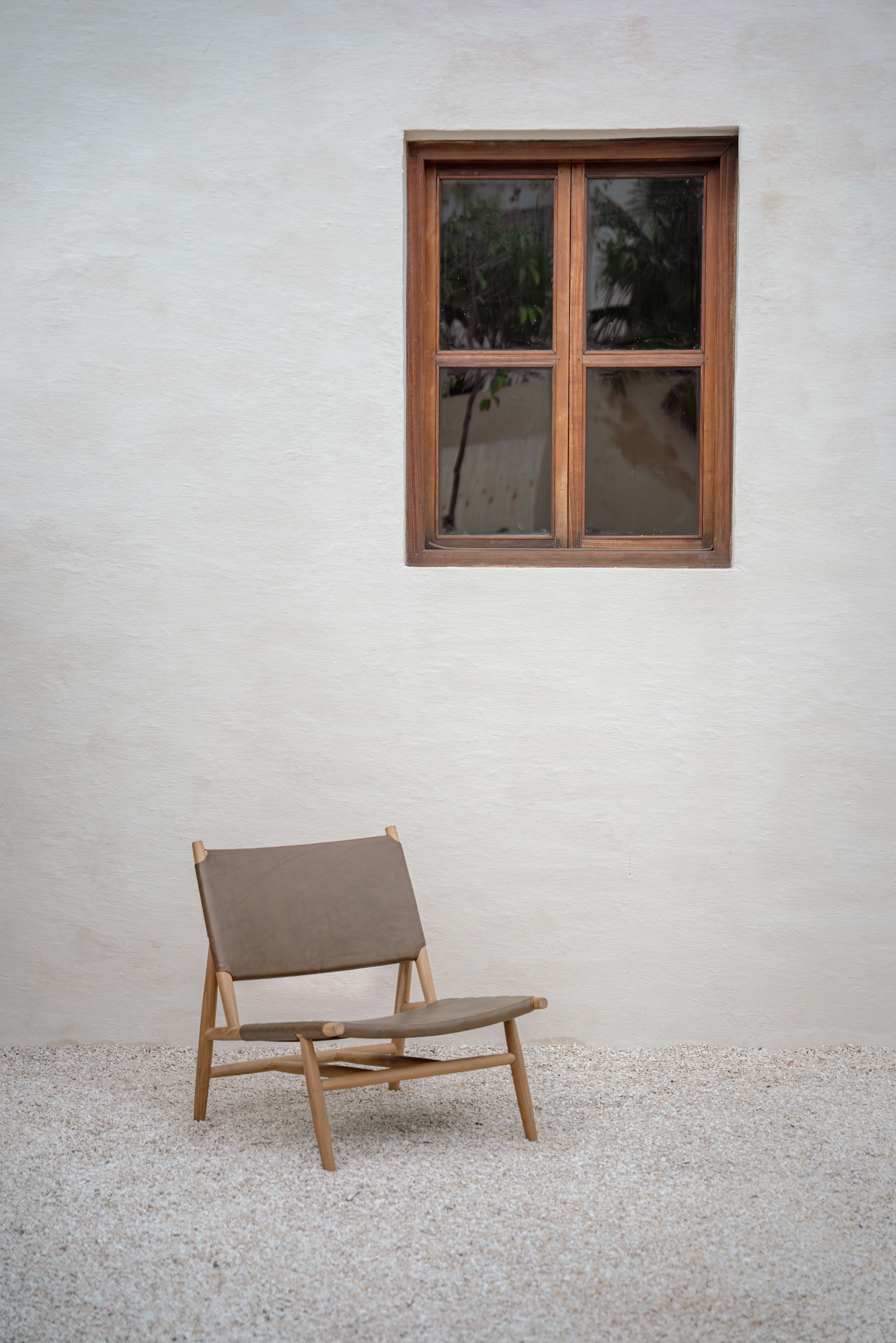 Leather and teak lounge chair in a small courtyard