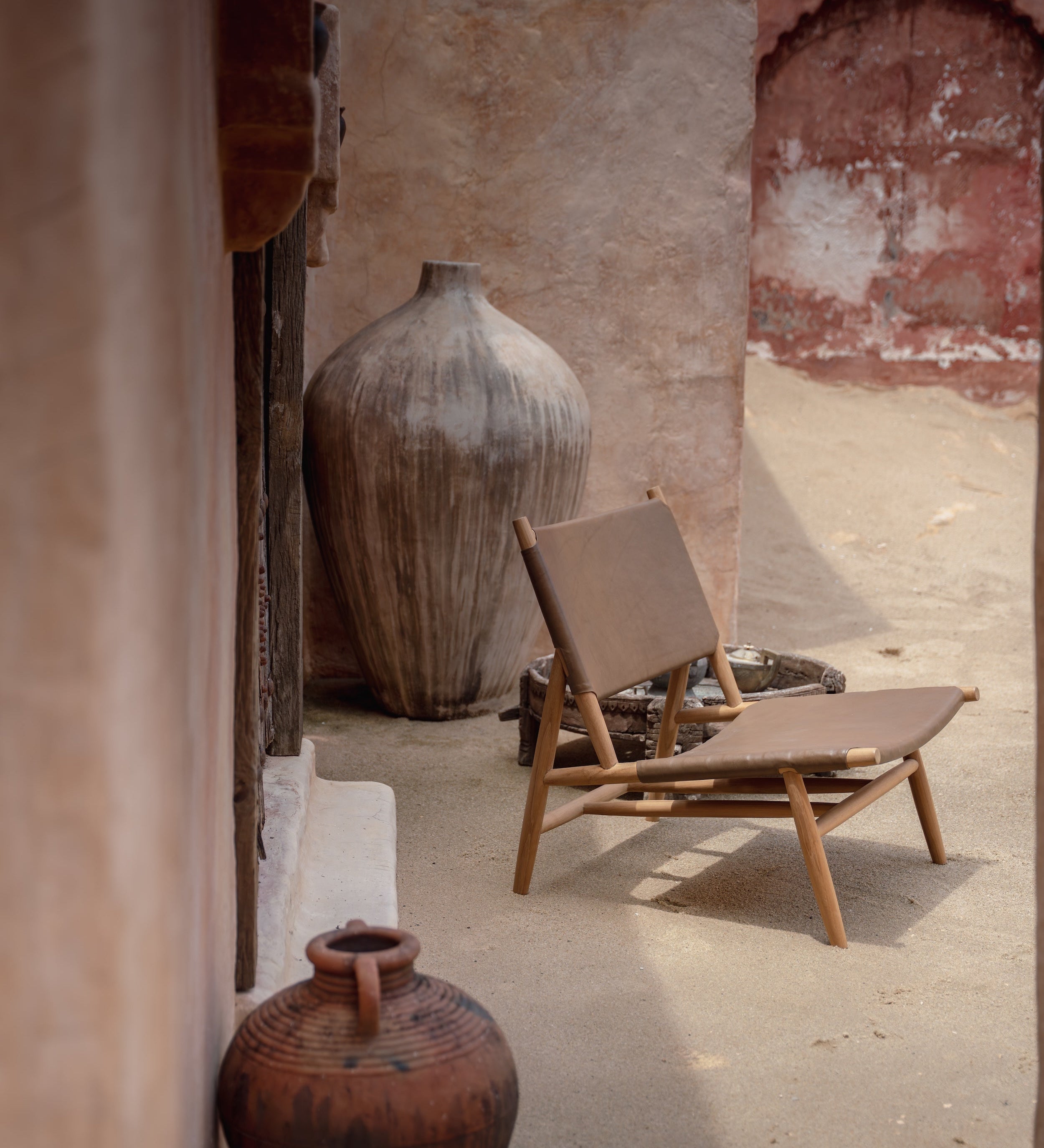 Leather and teak lounge chair in a rustic setting