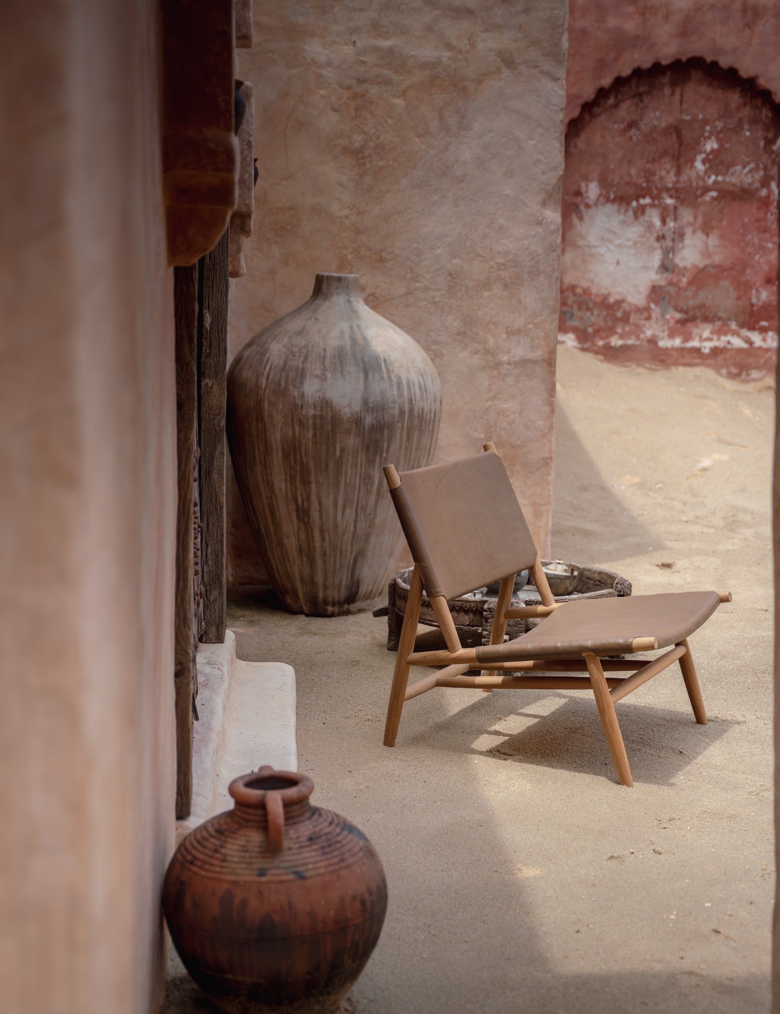 Leather and teak lounge chair in a rustic setting