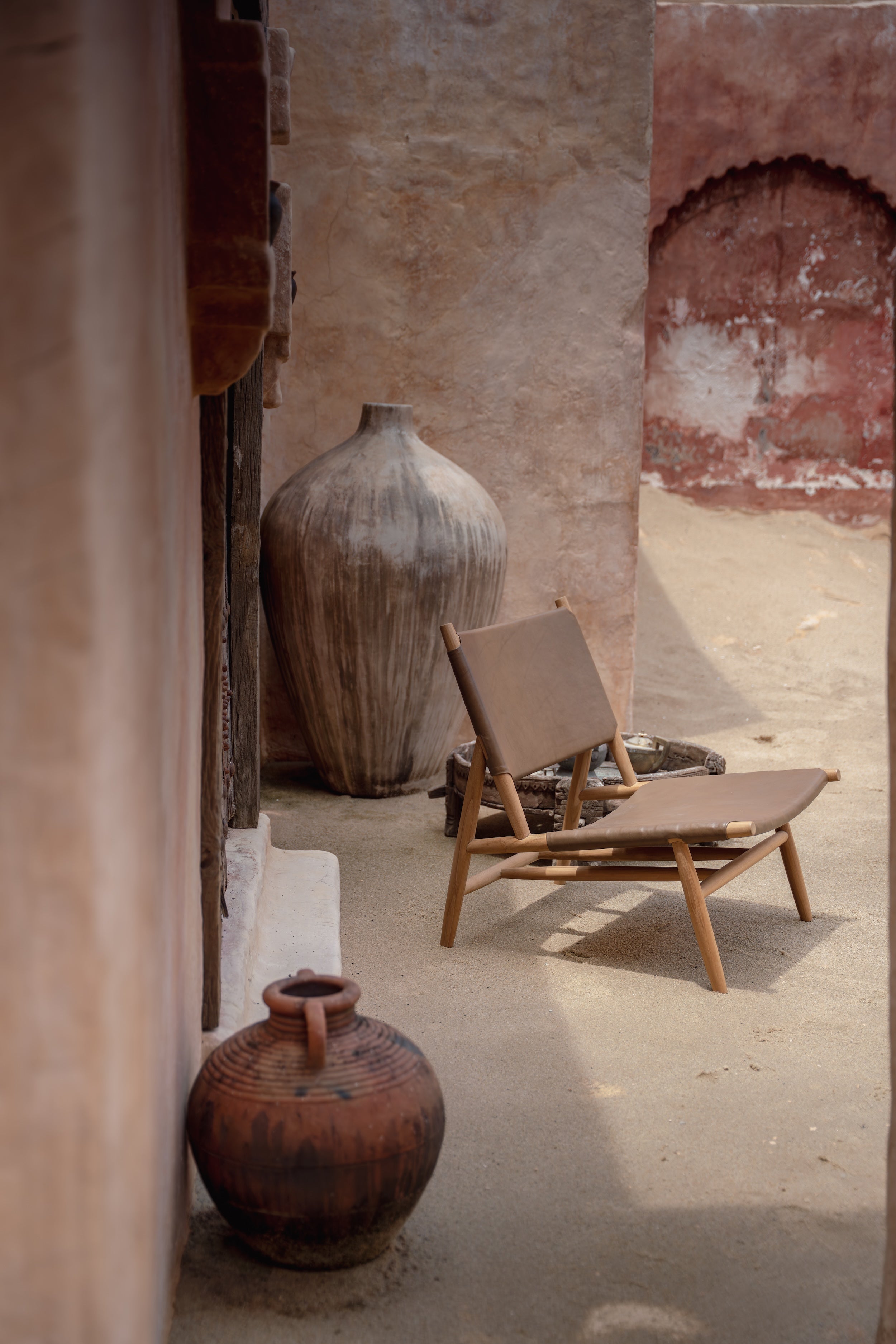 Leather and teak lounge chair in a rustic setting
