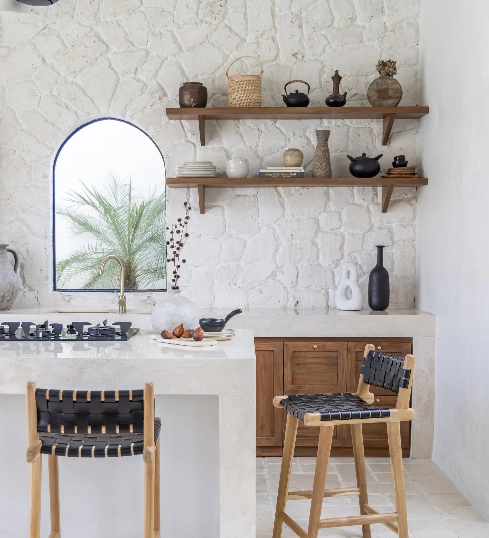black leather and teak stool in a kitchen with floating wooden shelves