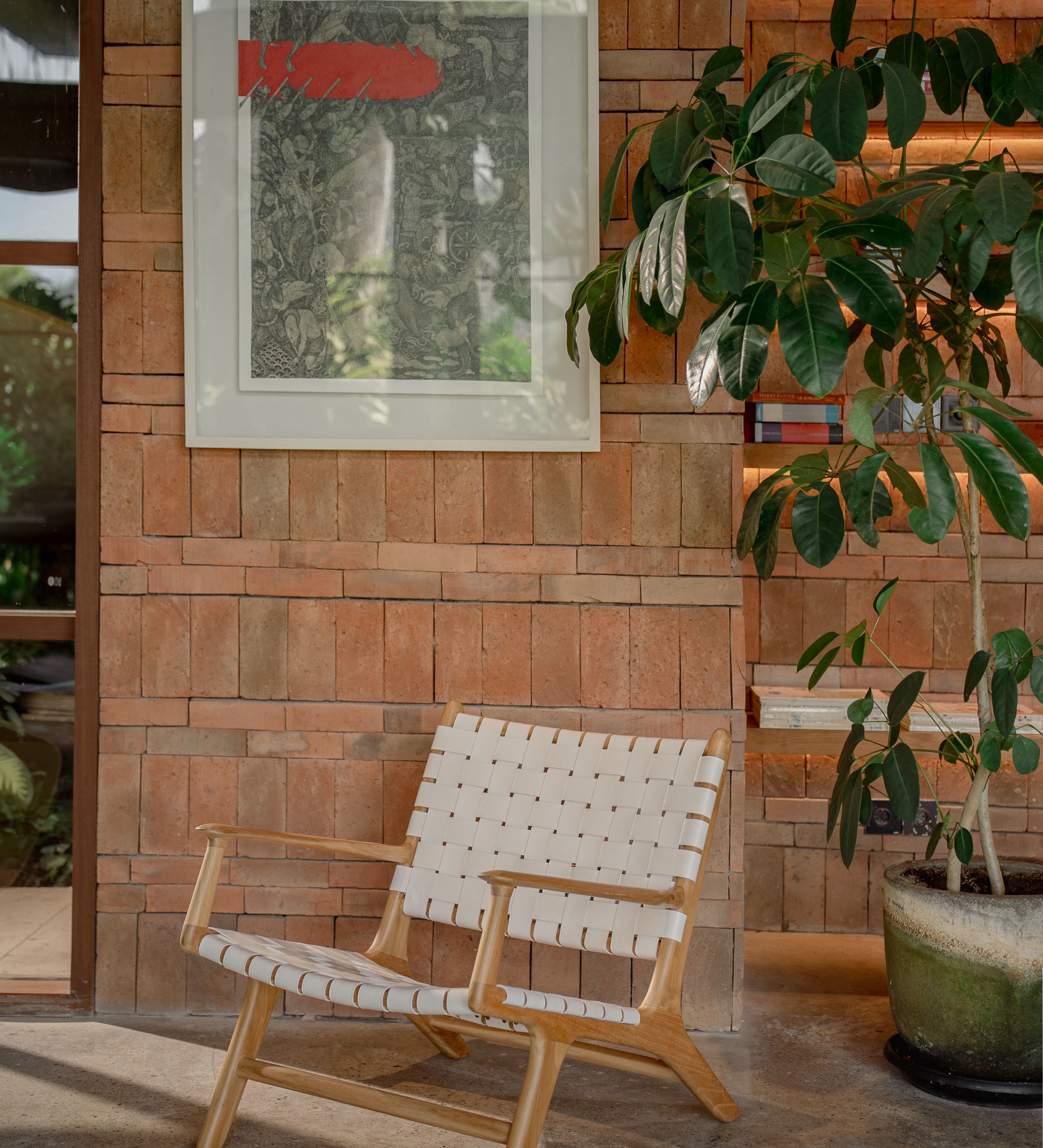 leather and teak lounge chair with a big plant next to it and nice artwork behind