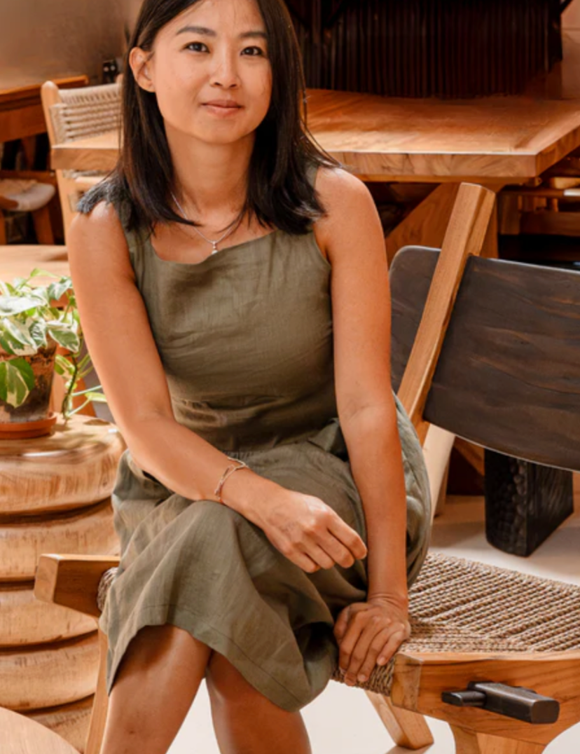 A woman is sitting on a chair smiling