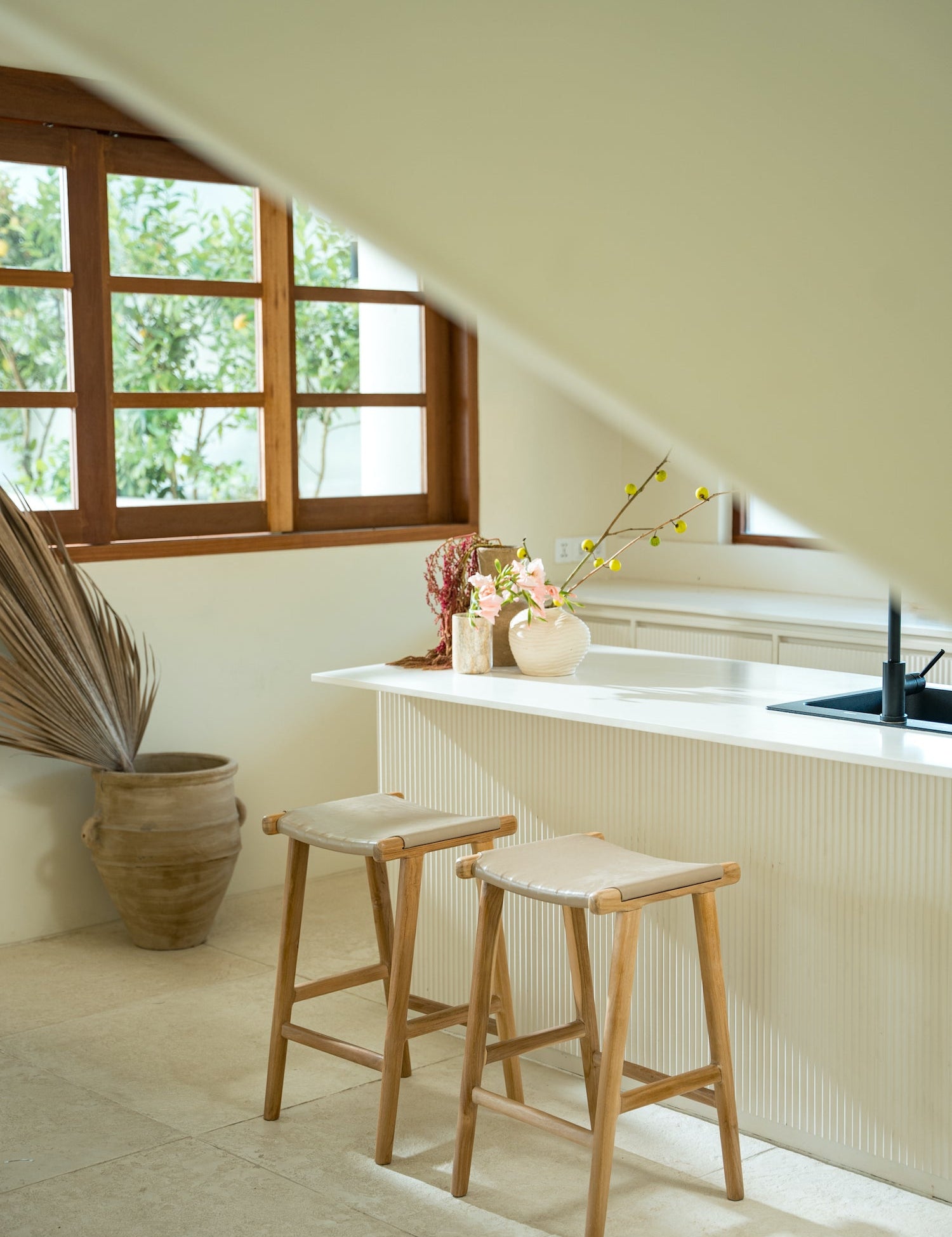 two bar stools with white leather and teak legs