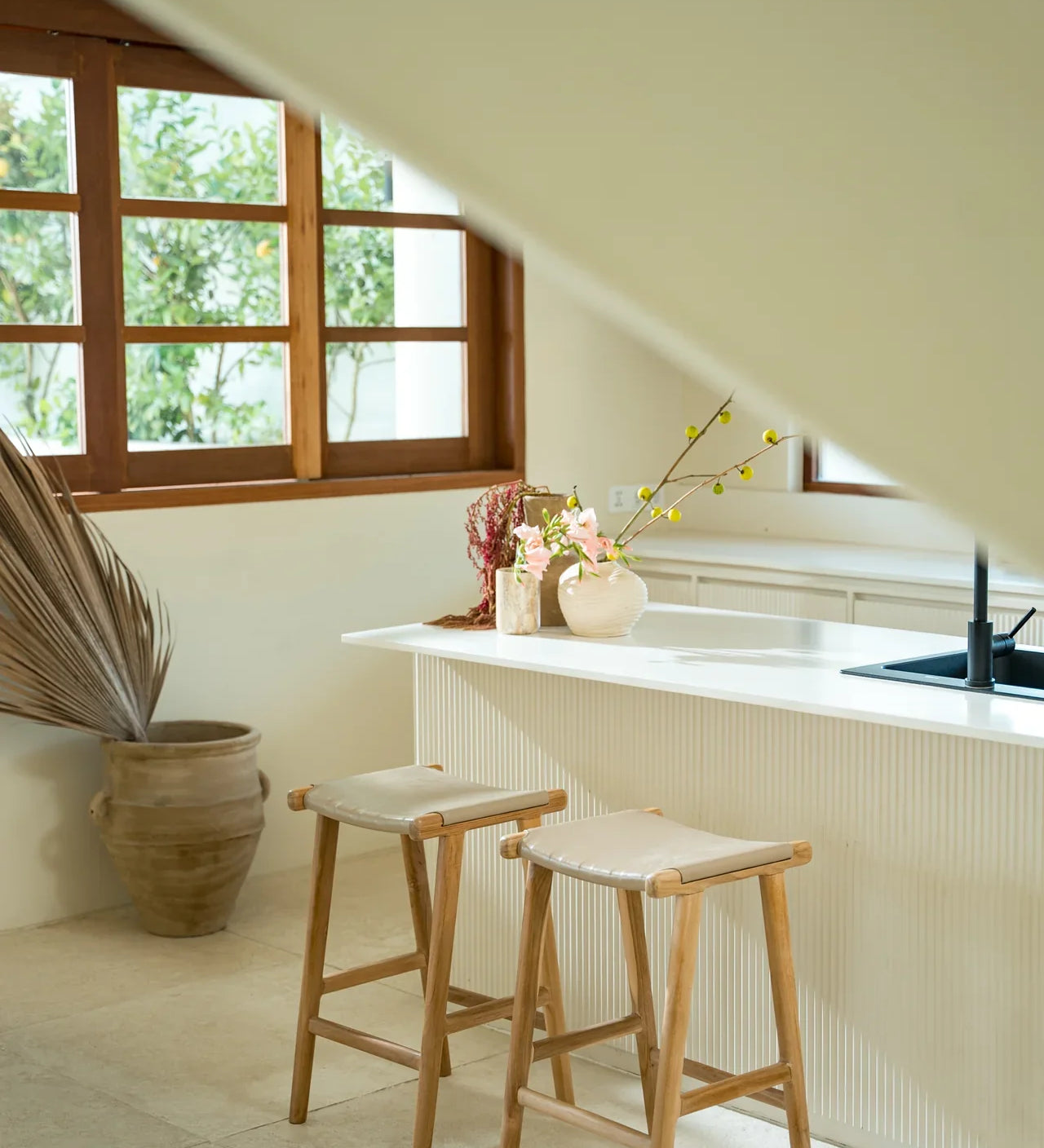 Modern white kitchen with white leather and natural teak kitchen counter stools