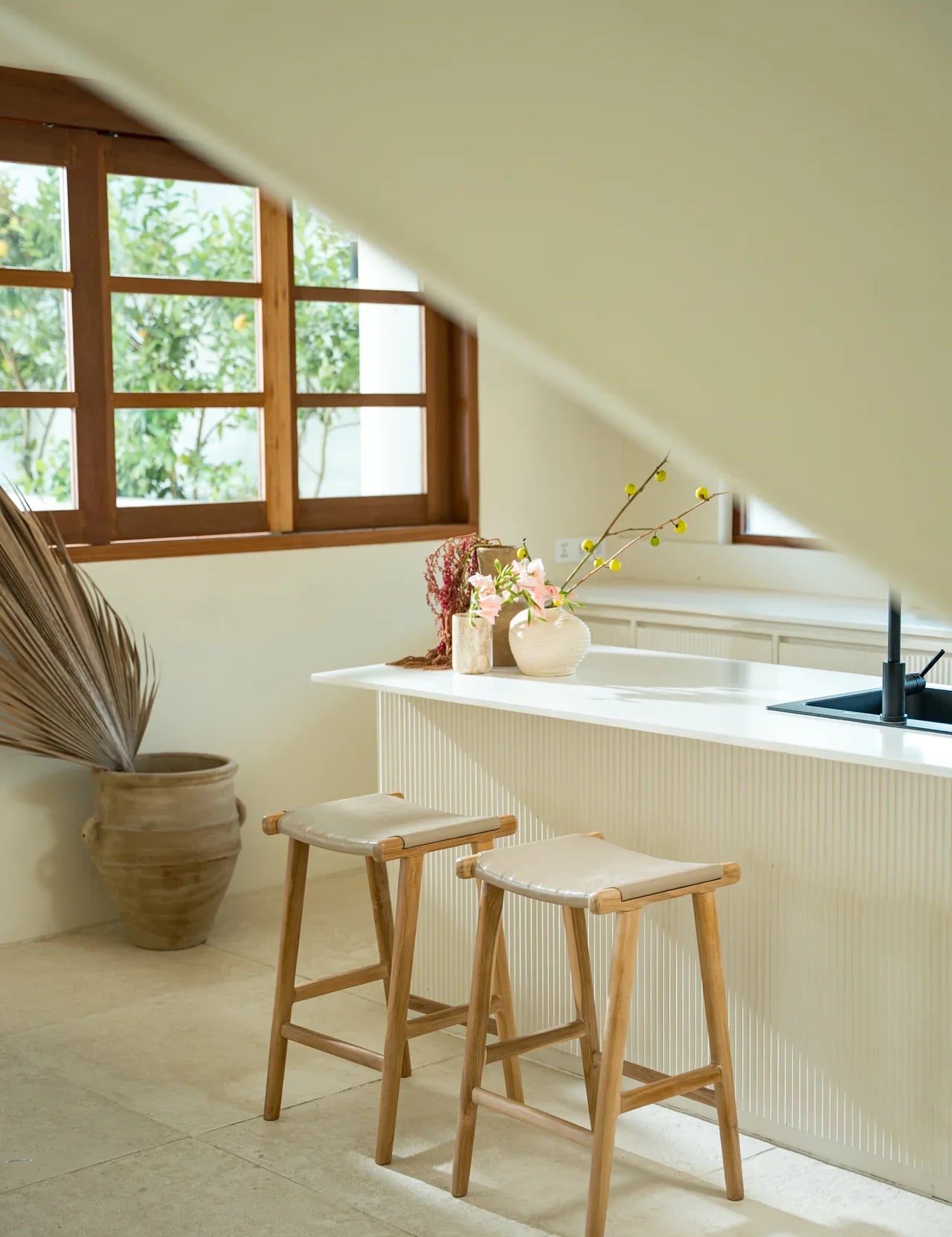 Modern white kitchen with white leather and natural teak kitchen counter stools