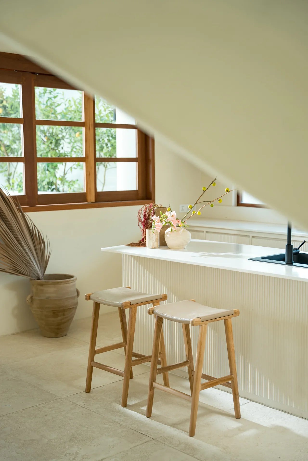 Modern white kitchen with white leather and natural teak kitchen counter stools